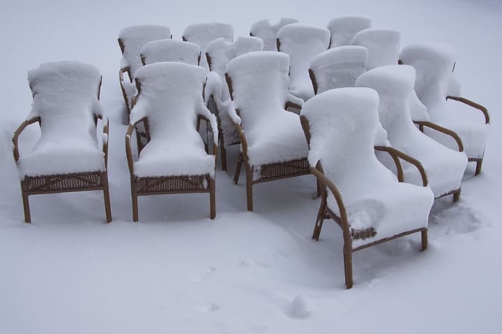 rattan furniture covered in snow