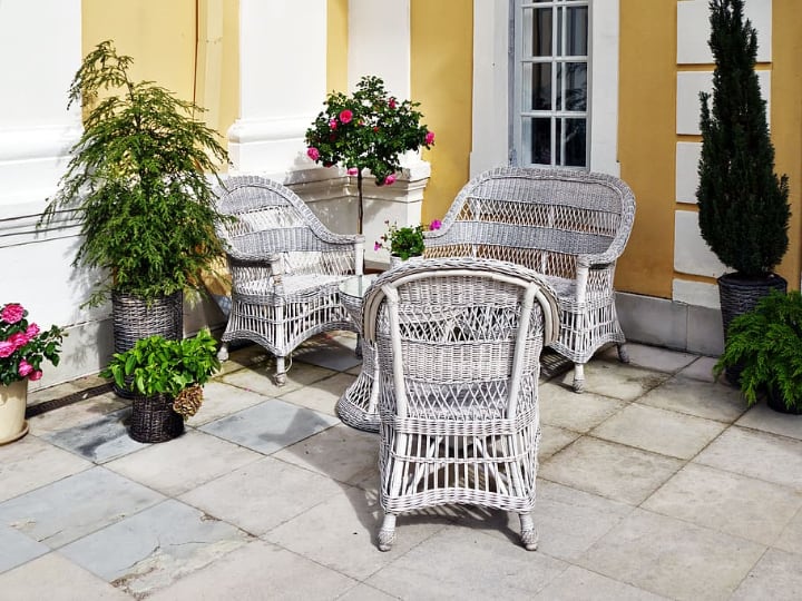 rattan garden furniture surrounded by plants