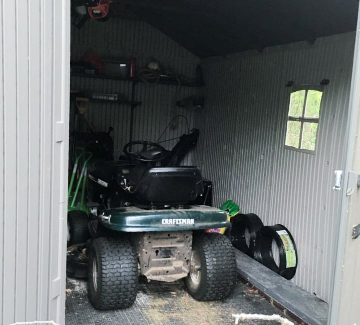 garden shed with wheel lawn mower inside