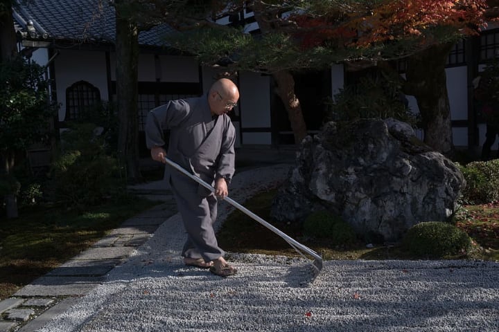 person who smoothens gravel on rock garden