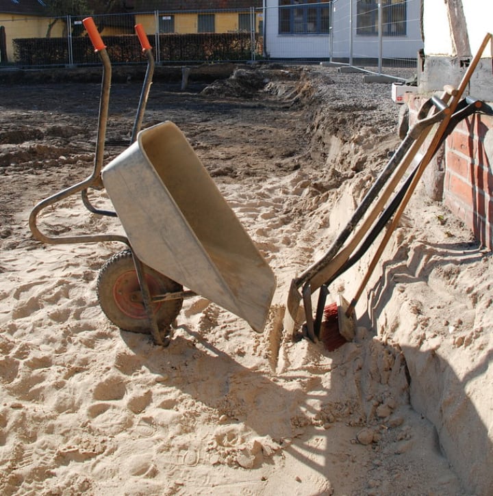 wheelbarrow shovel and trowels in the garden