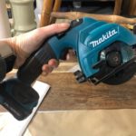 holding a mini circular saw