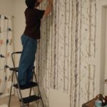 using a step ladder to install wallpaper