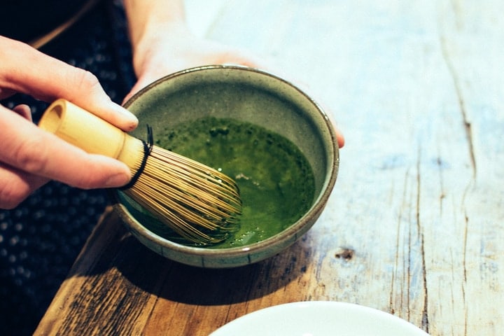 whisking the matcha green tea